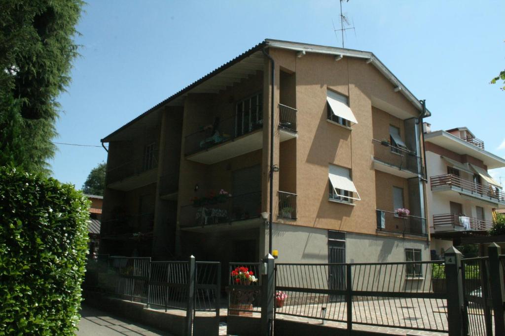 un immeuble d'appartements avec une clôture devant lui dans l'établissement Stop and Go, à Olgiate Comasco