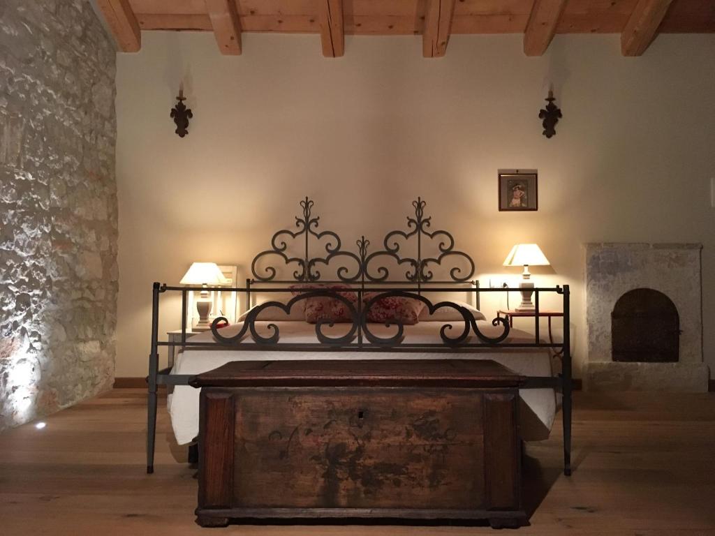 un letto d'epoca in una stanza con camino di Borgo Palazzo Steffaneo a San Vito al Torre