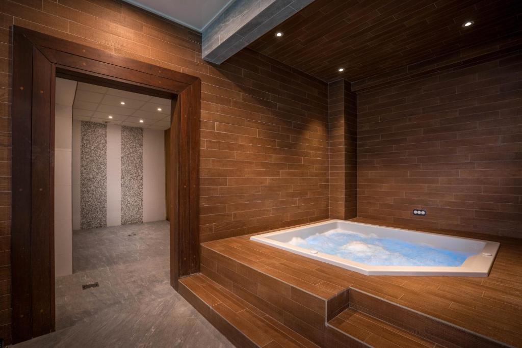 a jacuzzi tub in a room with a brick wall at Best Western Plus Hostellerie Du Vallon in Trouville-sur-Mer