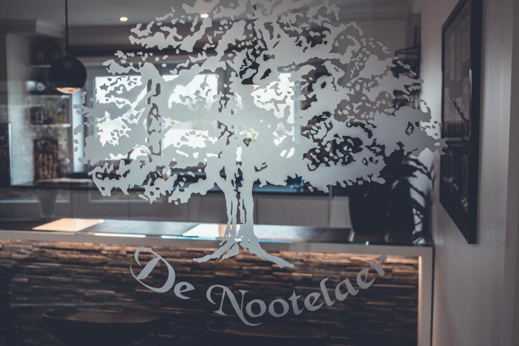 une photo d'un arbre sur une fenêtre dans l'établissement B&B De Nootelaer, à Meldert