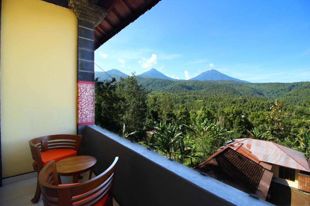 balcón con sillas y vistas a las montañas en Edy Homestay, en Munduk