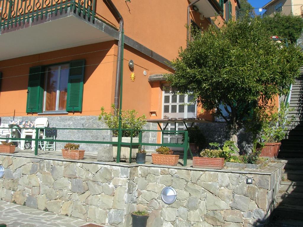 a house with a stone wall and a tree in front of it at Primario in Levanto