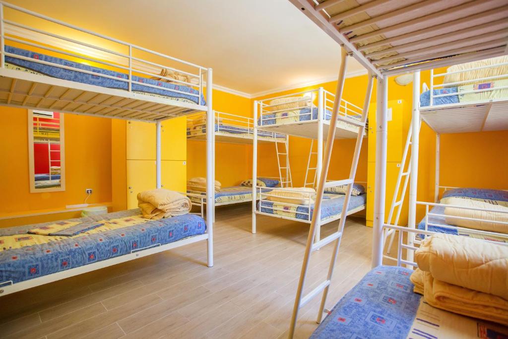 Camera con 4 letti a castello in una camera gialla di Outlanders Tribe Hostel a Spalato (Split)
