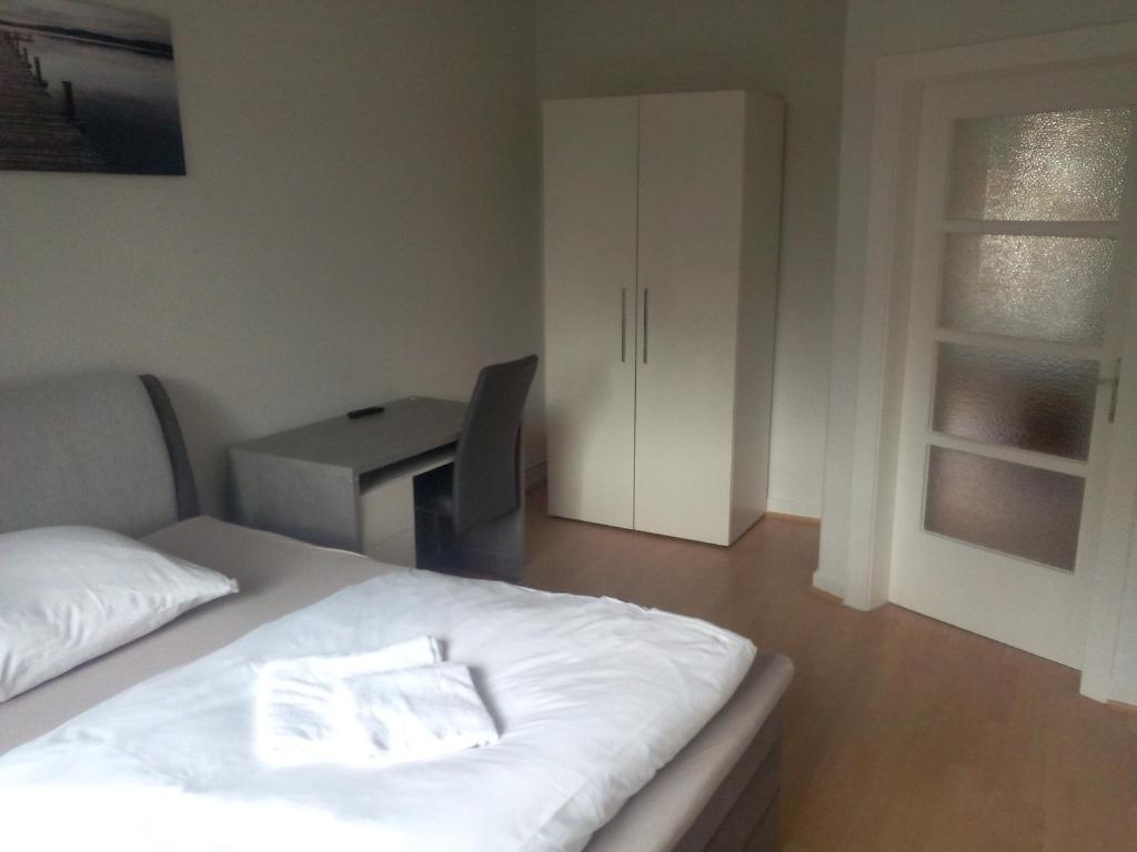 - une chambre avec un lit blanc et un bureau dans l'établissement Apartment Donau, à Hanovre