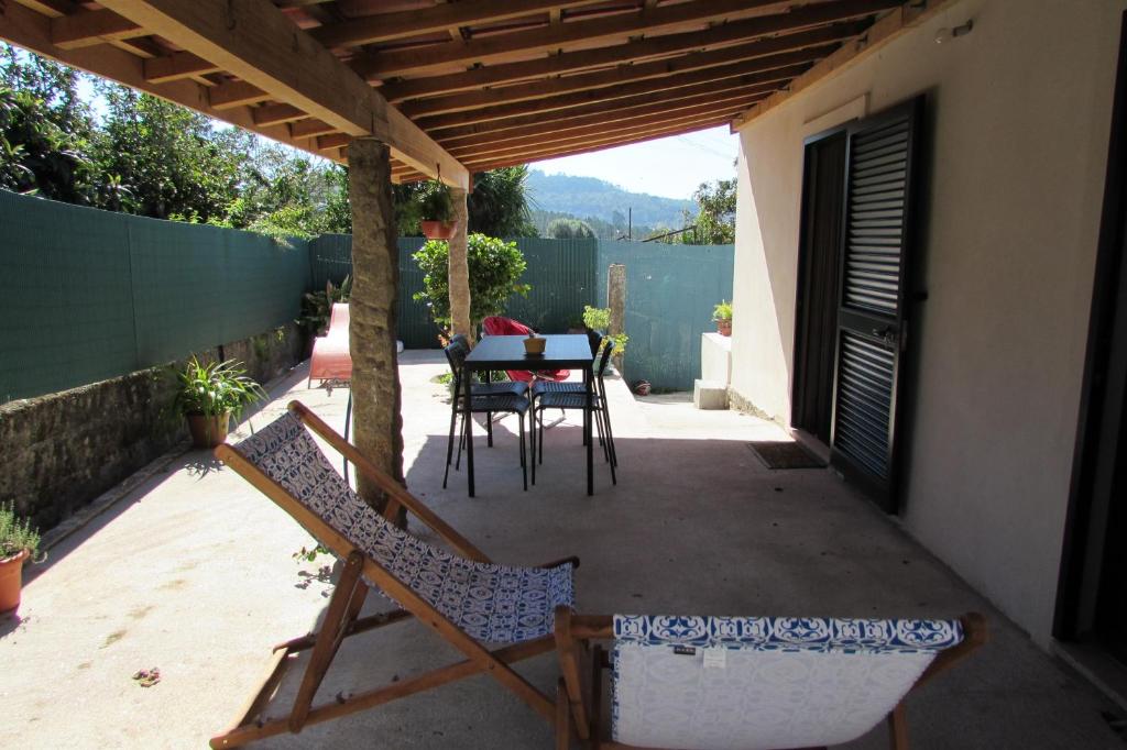 a patio with a table and chairs under a pergola at Casas da Nazare in Ponte de Lima