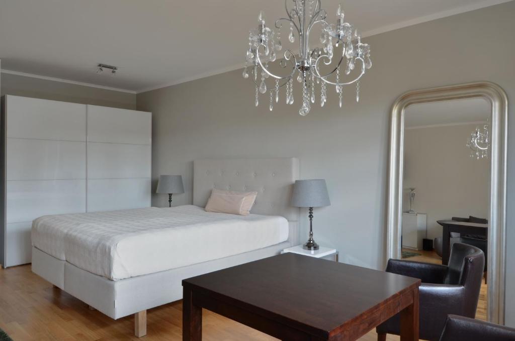 a bedroom with a bed and a table and a chandelier at Dresden City Exklusiv in Dresden