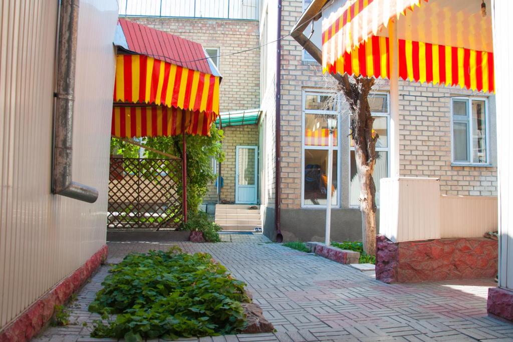 a building with red and orange umbrellas on a sidewalk at Sakura Guesthouse in Bishkek