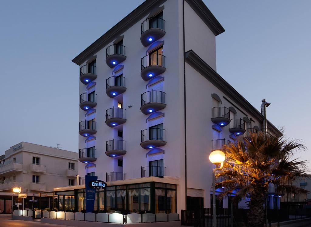 リミニにあるHotel Emiliaの青い灯りが横に見える建物