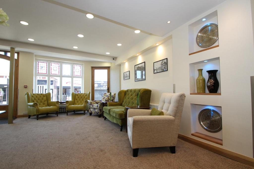uma sala de espera com cadeiras e uma lareira em The Ormonde Guesthouse em Chester