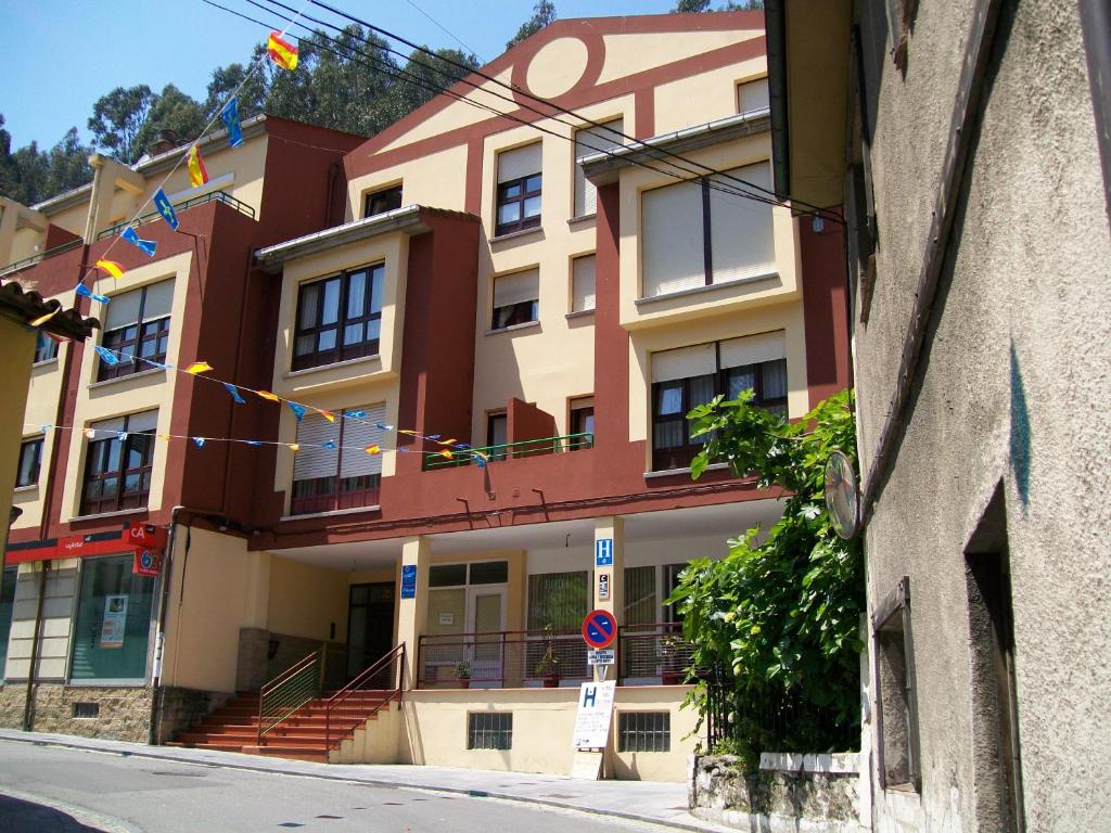 a building with flags hanging in front of it at Hotel Sol de la Blanca in Cudillero