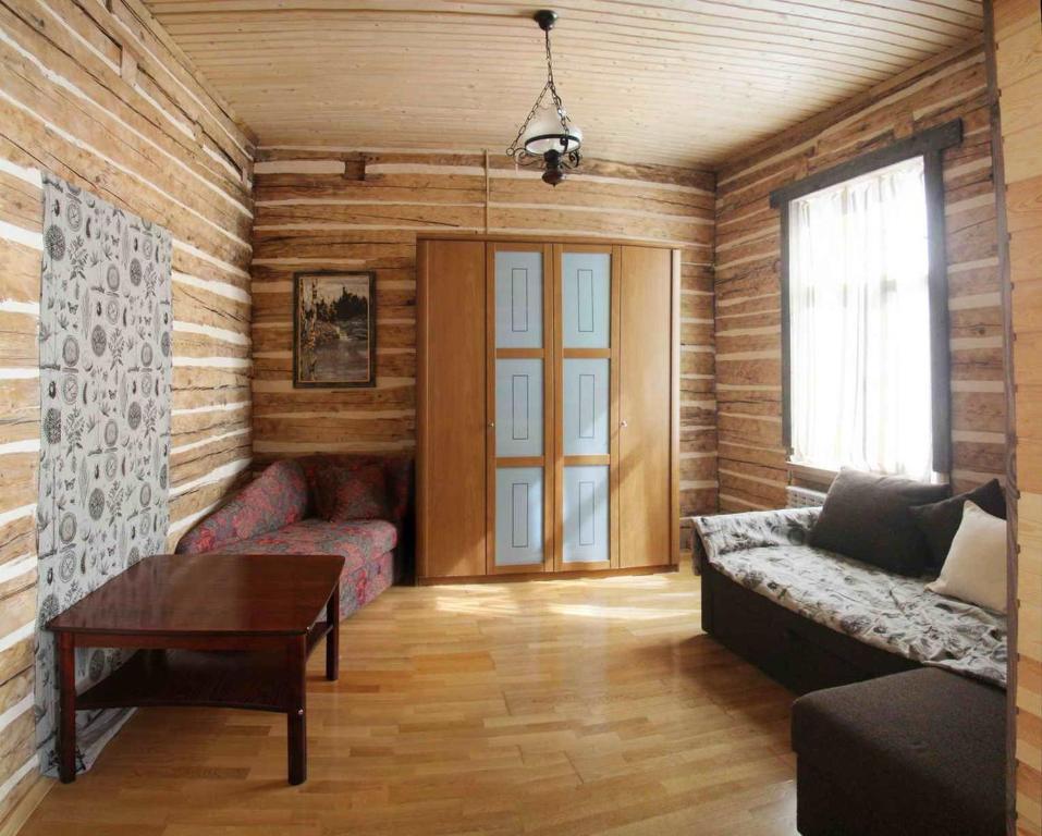 ソルタヴァラにあるLog cabin in the centerの木製の壁のリビングルーム(ソファ、テーブル付)