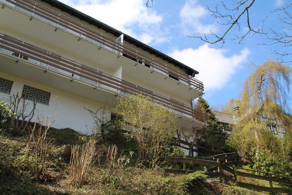 Ein weißes Gebäude mit einem Zaun daneben. in der Unterkunft Appartement Nordenau in Schmallenberg