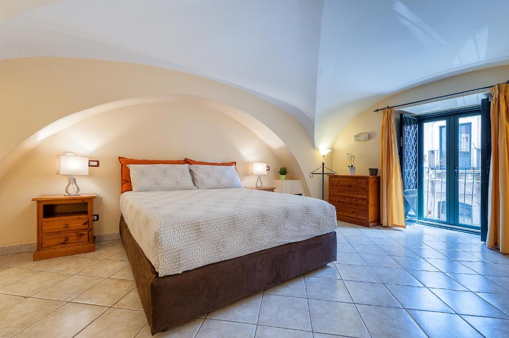 een slaapkamer met een bed en een groot raam bij Case Vacanze Catania in Catania