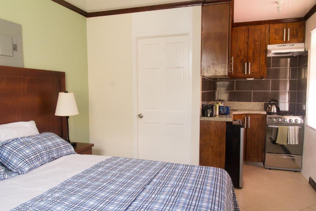 a bedroom with a bed and a kitchen at Believe Caribbean Apartment in Bridgetown