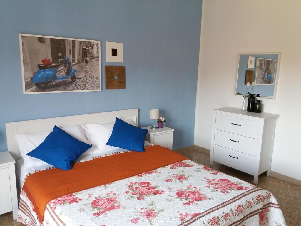 a bedroom with a large bed with blue walls at Near To Pisa Airport Guesthouse in Pisa