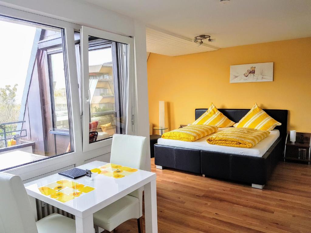 メーアスブルクにあるFerienapartment Seeblickのベッドルーム1室(黄色い枕とテーブル付きのベッド1台付)