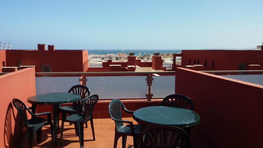 a balcony with tables and chairs on a roof at Apartamento fuerte 1 in Puerto del Rosario