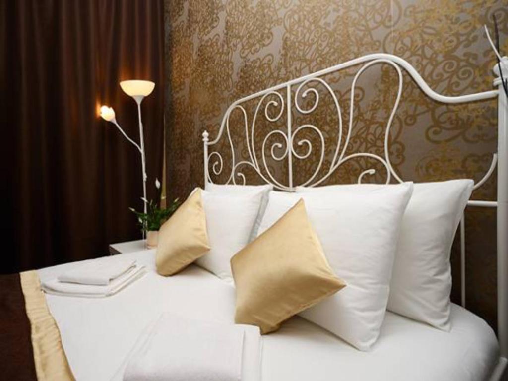 a white bed with white pillows in a room at Guest Rooms Apelsin on Victory Park in Moscow
