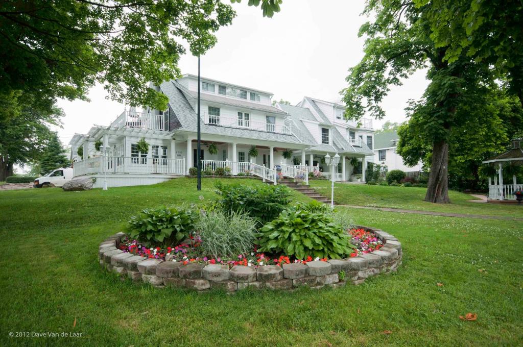 a large white house with a flower bed in the yard at Chestnut Inn in Niagara Falls