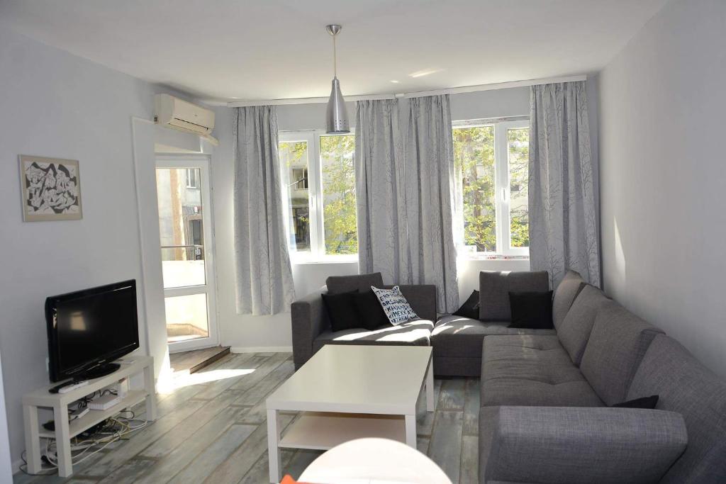 a living room with a couch and a tv at Ivet Apartment in Varna City