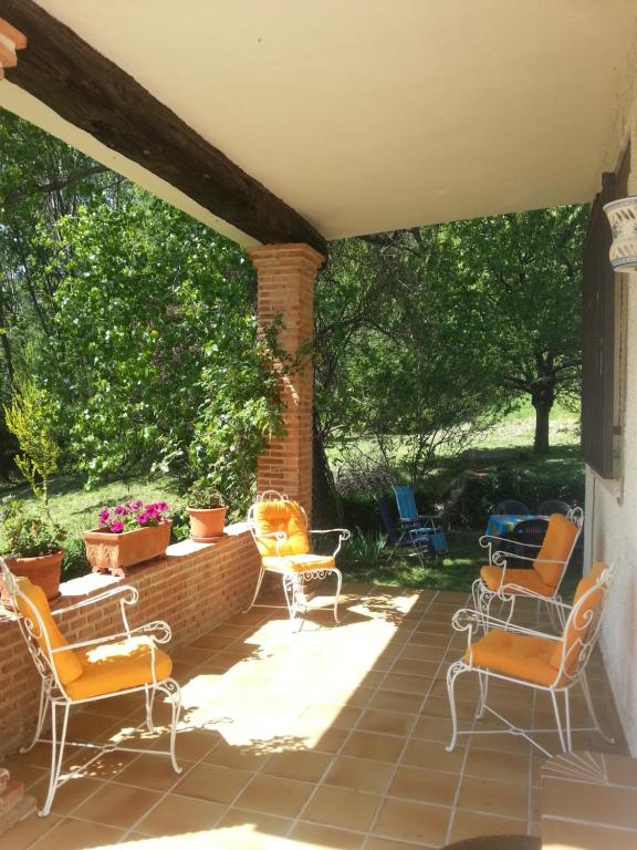 a patio with chairs and a brick wall at Casa El Prao in Arenas de San Pedro