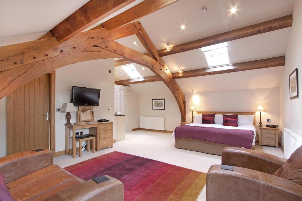 um quarto com uma cama king-size e uma televisão em Cold Cotes Harrogate em Harrogate