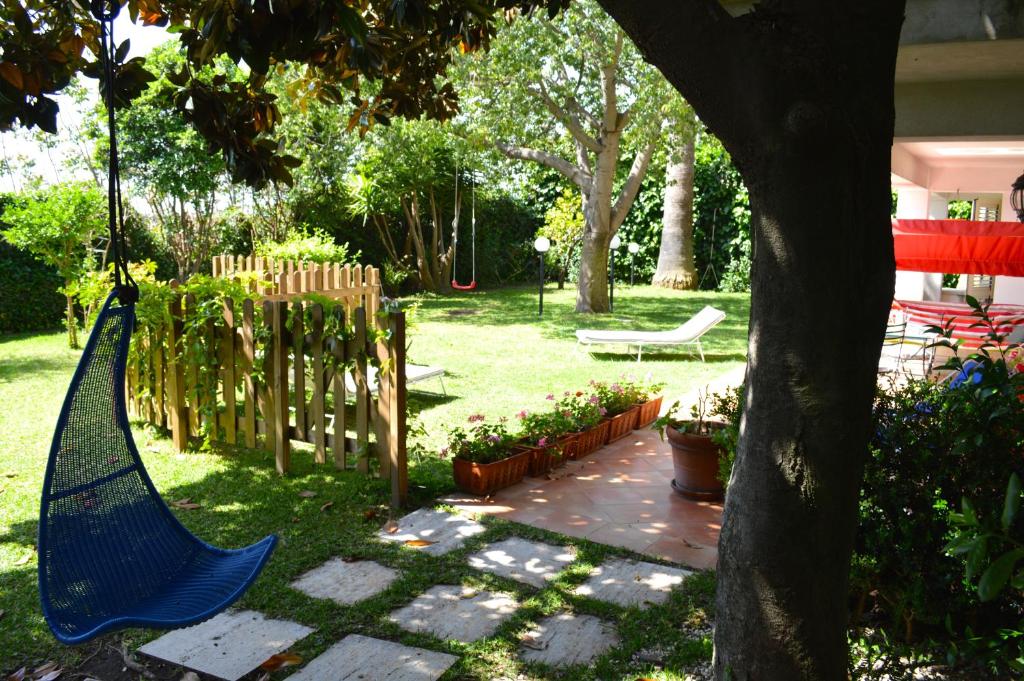 una hamaca azul colgando de un árbol en un patio en Casa Magnolia en Gravina di Catania