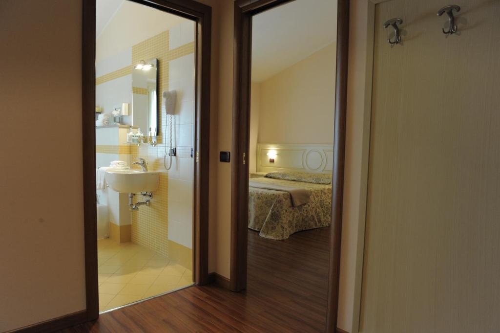 Pokój z łazienką z umywalką i łóżkiem w obiekcie Hotel Plazza w mieście Porcari
