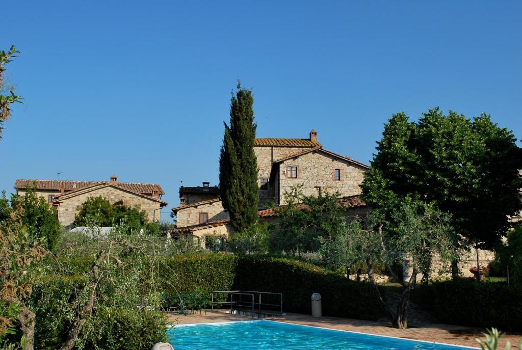 a villa with a swimming pool in front of a building at Agriturismo San Sano in Gaiole in Chianti