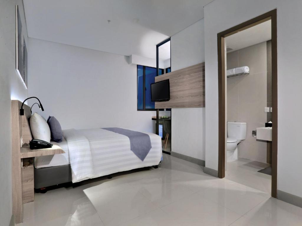 Postel nebo postele na pokoji v ubytování Hotel Neo Gajah Mada Pontianak by ASTON