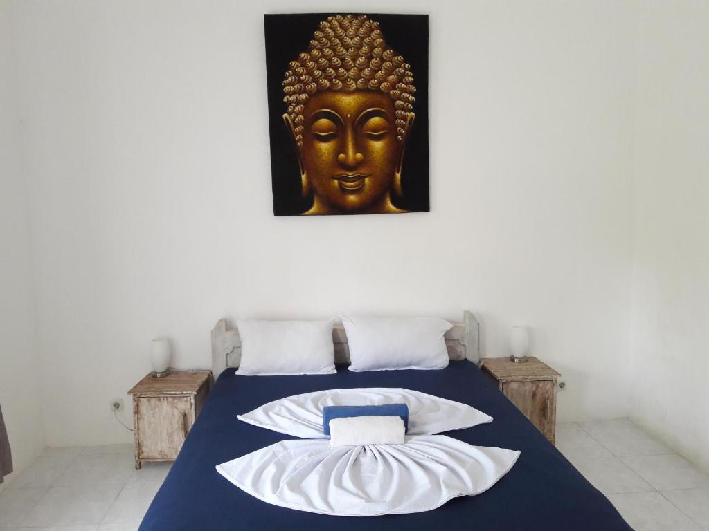 a bedroom with a bed with a gold mask on the wall at Wombat's B&B in Gili Trawangan