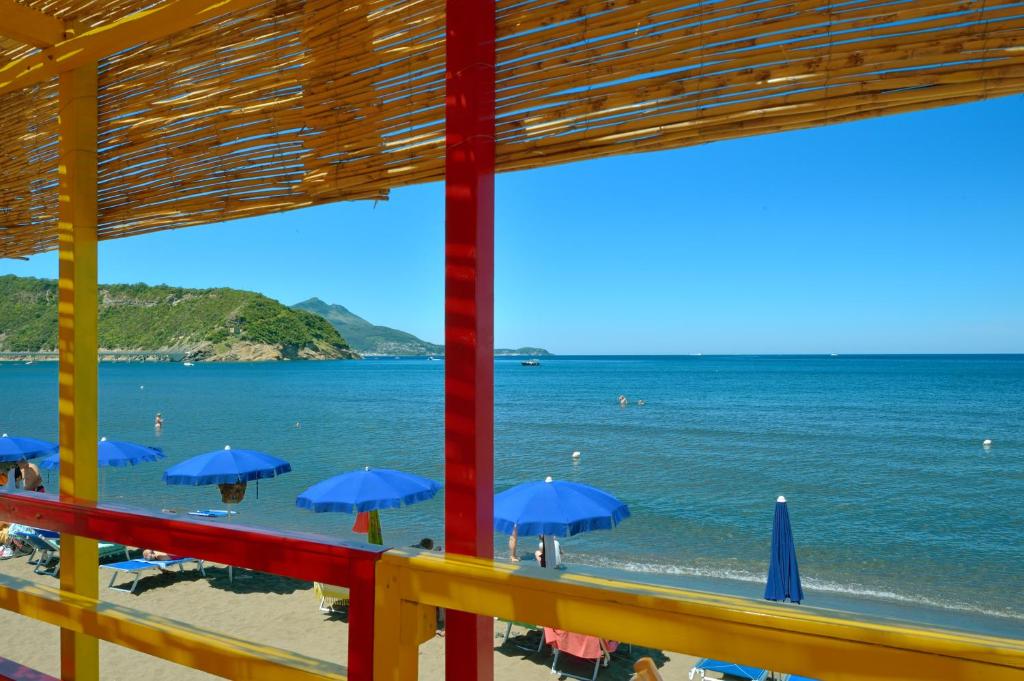 a view of a beach with blue umbrellas at La Capannina in Procida