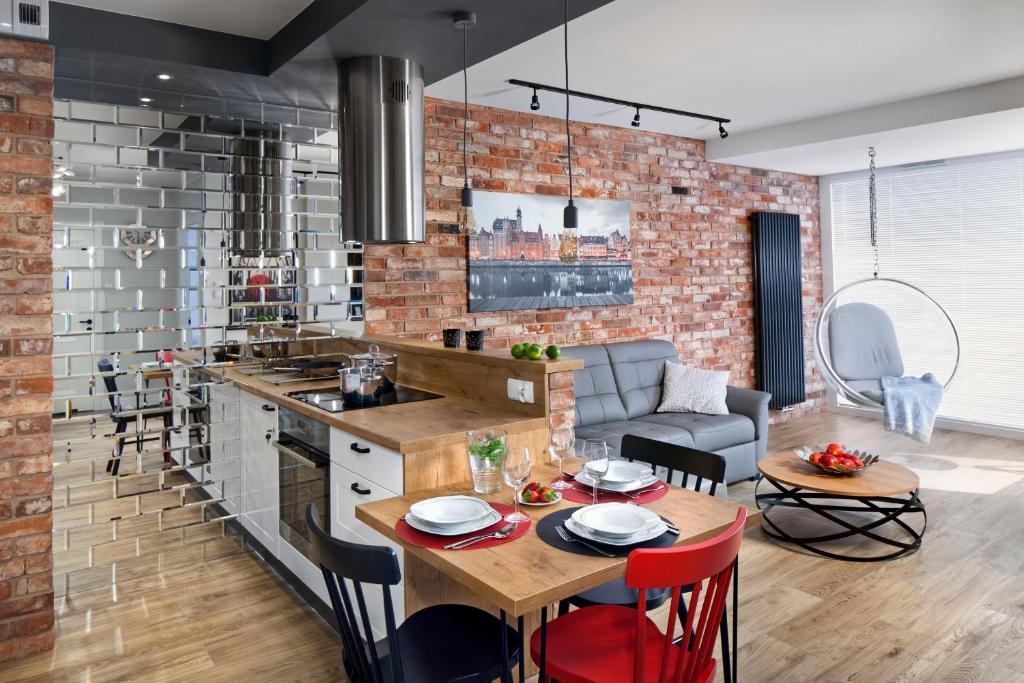 a kitchen and living room with a table and chairs at Apartament No 118 in Gdańsk