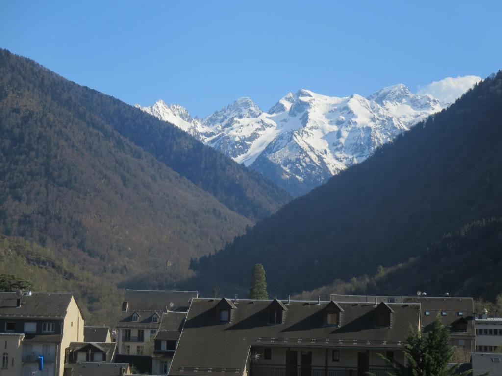 Pyrénées Palace في لوشون: مدينة بها جبال مغطاة بالثلوج في الخلفية