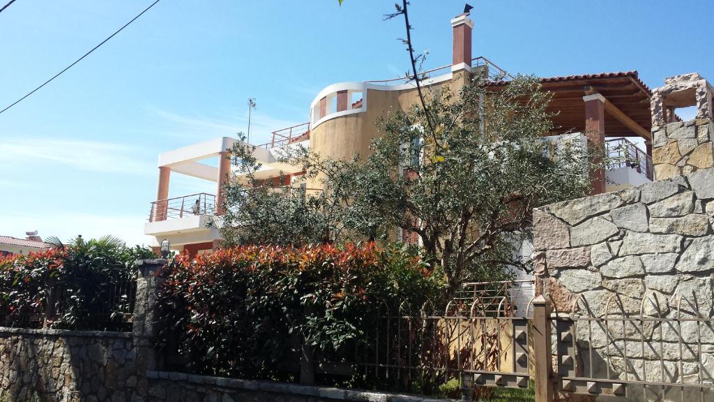 a building with a stone wall and a fence at Villa Demy in Patra