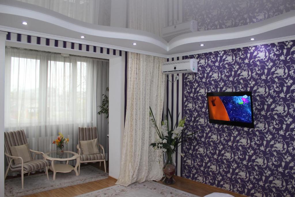 een woonkamer met een tv aan een paarse muur bij Apartment Ecaterina in Chişinău