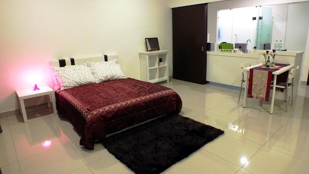 a bedroom with a bed and two tables and a mirror at Tranquil Studio @ Trefoil Setia Alam in Shah Alam