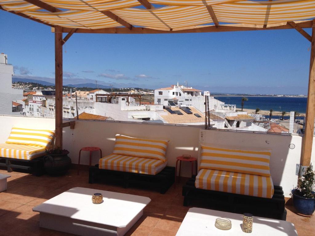 ラゴスにあるSol a Sol Hostelの海の景色を望むバルコニー(椅子、テーブル付)