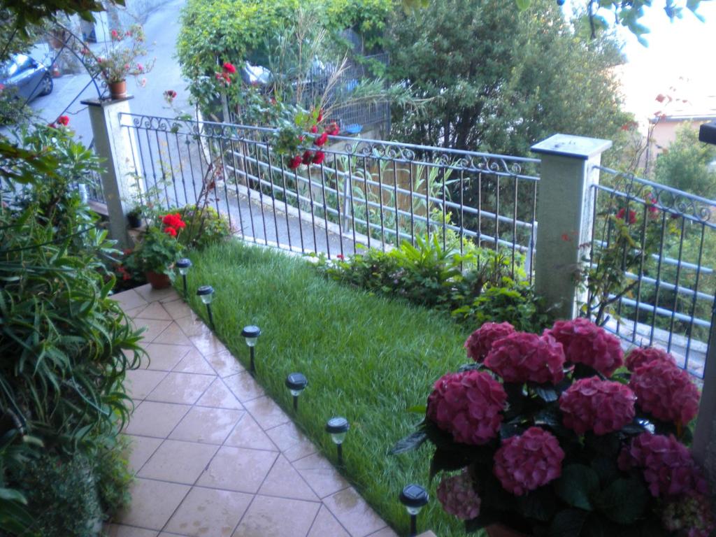 un jardín con flores en el césped junto a una valla en Cinqueterre Holidays, en Riomaggiore