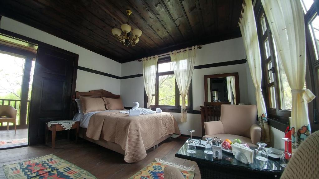 a bedroom with a bed and a chair and windows at Hotel Sadibey Ciftligi in Kasaba