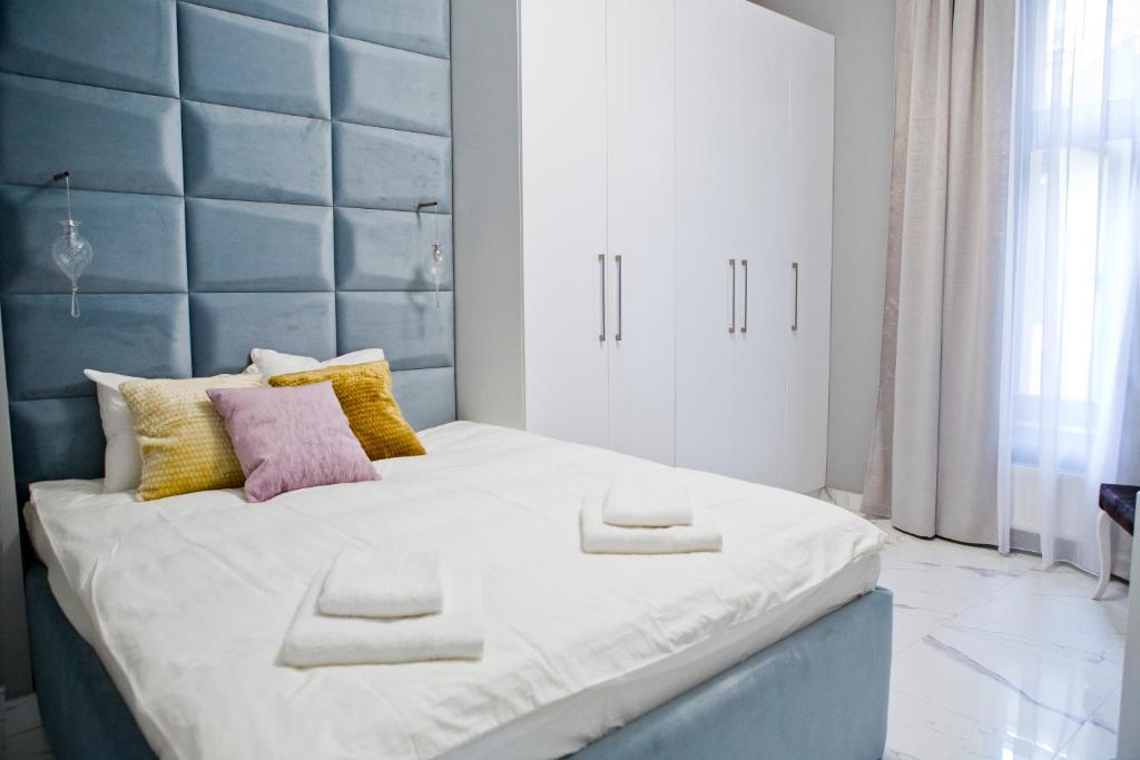 uma cama grande com uma cabeceira azul num quarto em Elegant City Center Zyblikiewicza 14 em Cracóvia
