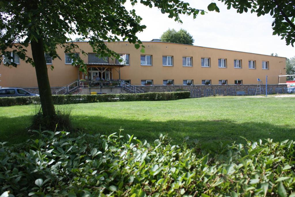 a large building with a lawn in front of it at Sporthotel BK Pod Lipou in Roudnice nad Labem