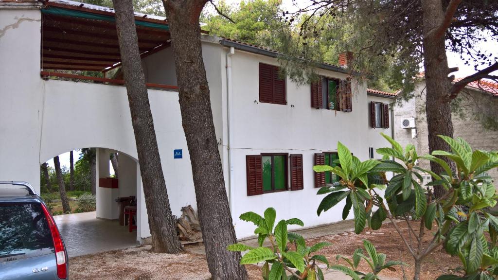 a white house with red and green shuttered windows at Apartments Vera - Mirca in Mirce