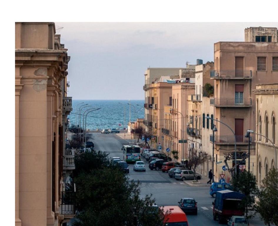 una via cittadina con edifici e l'oceano sullo sfondo di Apartment Trapani a Trapani