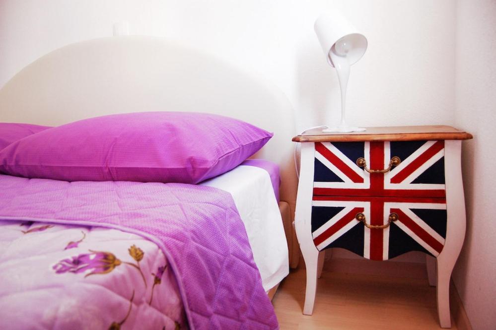 a bedroom with a bed and a side table with a flag at Good Spirit in Trogir