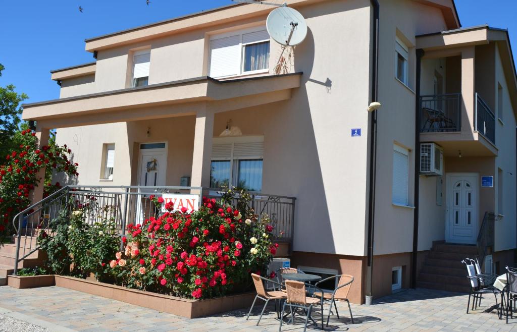 a house with chairs and flowers in front of it at Pansion Ivan in Međugorje