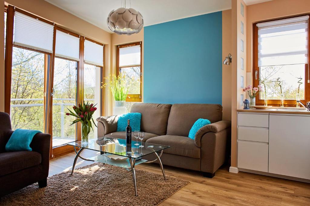uma sala de estar com um sofá e uma mesa em Sun Apartament - Królewskie Kamieniczki em Sopot