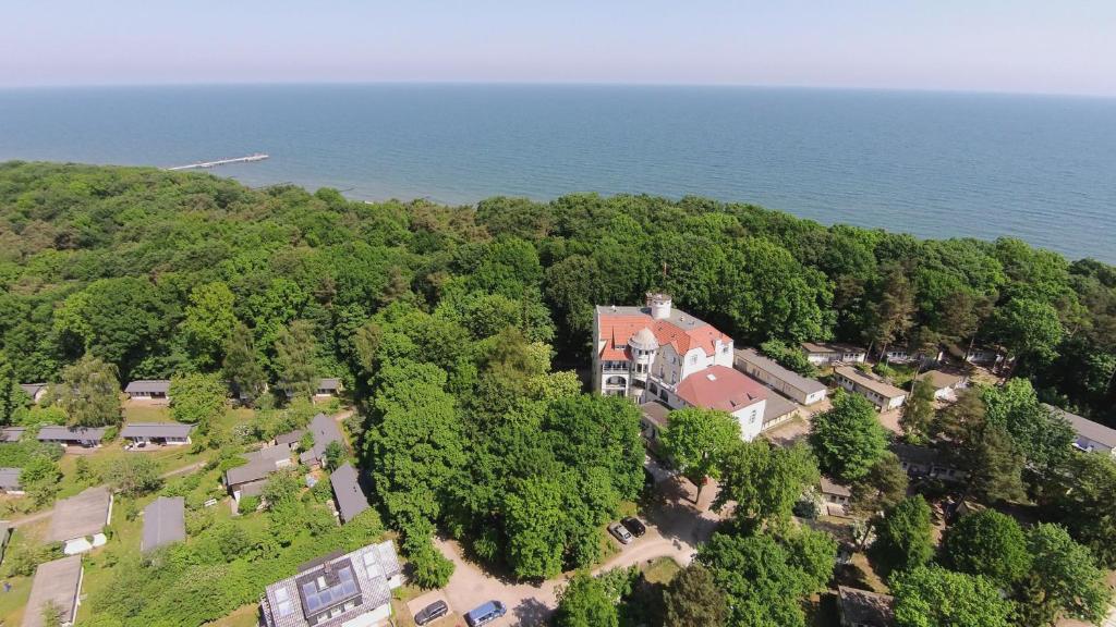 an aerial view of a house on a hill next to the ocean at Waldschloss Parow in Koserow