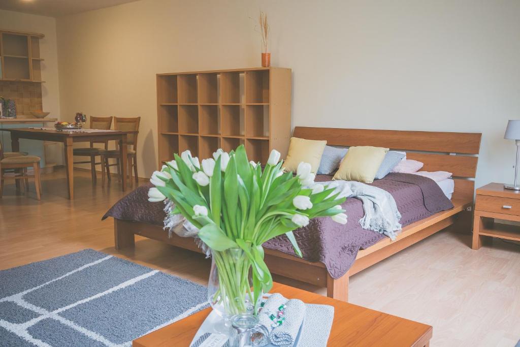 a vase of flowers on a table in a living room at Apartamenty przy Zamku in Olsztyn