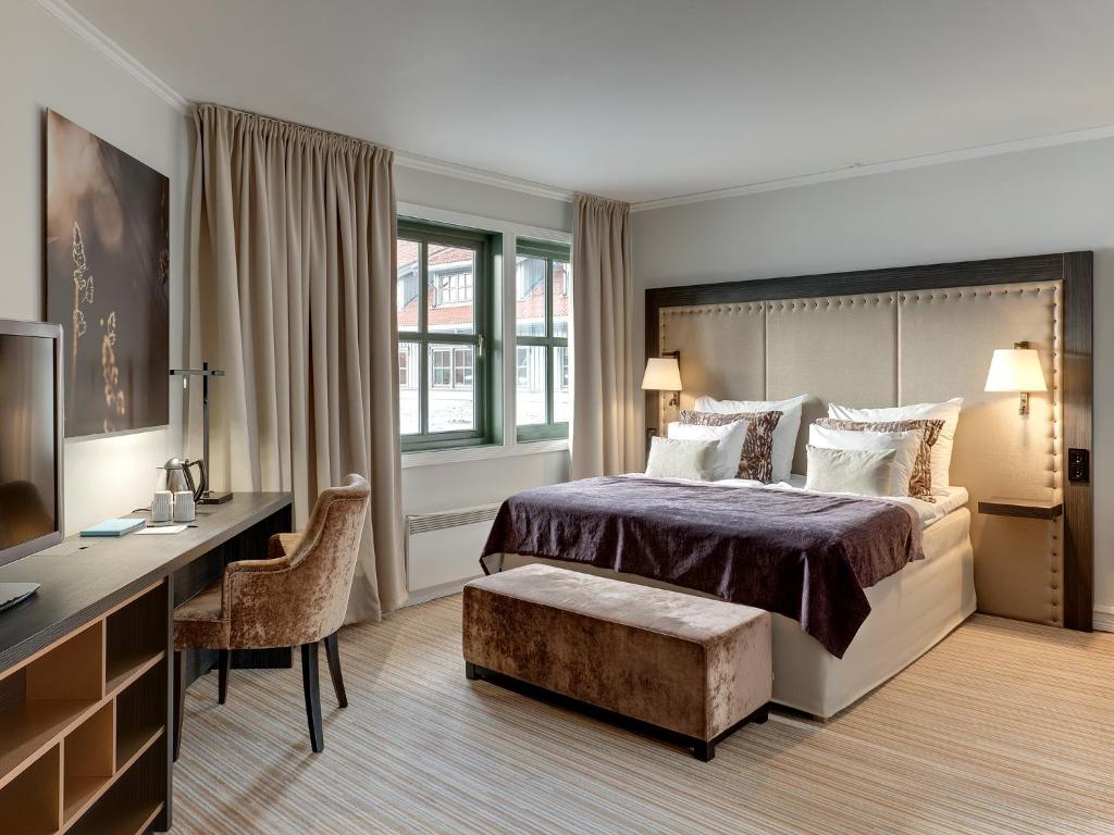 ガーデモエンにあるClarion Hotel Oslo Airportのベッド、デスク、テレビが備わるホテルルームです。